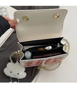 Top view of cream crossbody bag interior showing spacious compartments and zip pocket