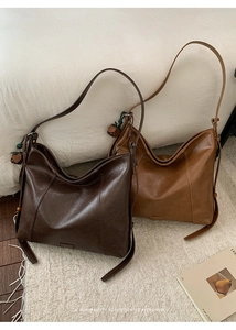 Détail de grands sacs fourre-tout en similicuir marron et fauve sur un tapis tissé