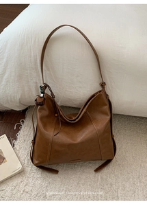 Détail de la texture en cuir PU marron et du nœud latéral sur ce sac fourre-tout