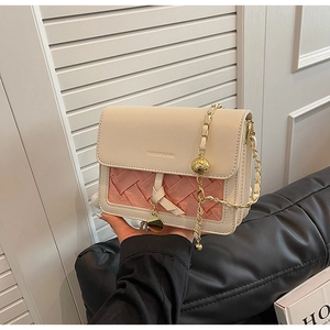 Detail of pink woven texture and cream flap on a small crossbody bag with gold chain