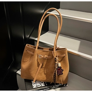 Detailed macro view of dark brown leather tote bag with a leopard print heart charm