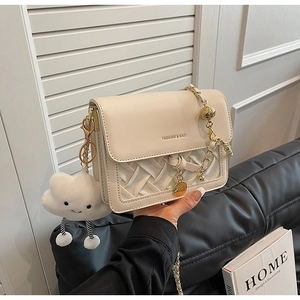 Detail of off-white retro square bag featuring woven texture and gold chain strap