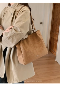 Macro detail of large brown suede tote bag featuring minimalist design and slim straps