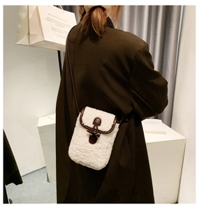 Detailed back view of a white fleece crossbody phone bag with leather trim and horn buckle