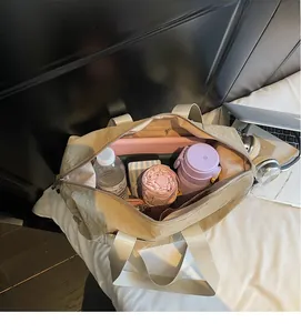 Macro view of spacious interior of a beige tote bag holding a laptop and essentials