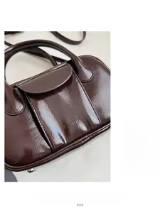 Detail of glossy oil-wax leather bowling bag in deep brown with mirror-like finish