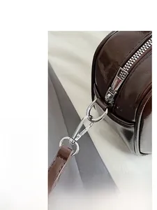 Close-up of silver metal zipper and hardware details on dark brown bowling bag