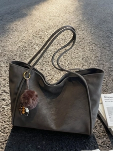 Retro charcoal grey suede tote bag with brown plush pendant shown in an outdoor setting