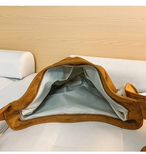 Vue intérieure du sac cabas en daim marron avec doublure grise et poche zippée latérale