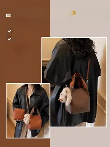 Detail view of brown vintage bucket bag set including a small pouch and rabbit charm