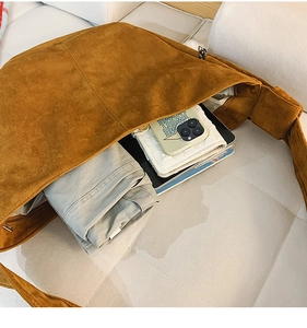 Vue détaillée de l'intérieur d'un grand sac hobo en daim marron avec des objets