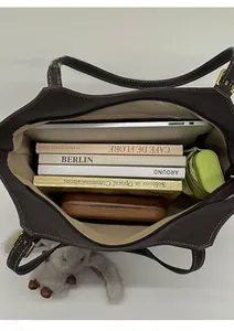 Vertical view of the spacious inner compartment of this brown leather tote bag