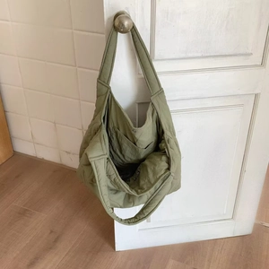 Detail view of the spacious inner pocket and soft quilted nylon fabric of the sage tote