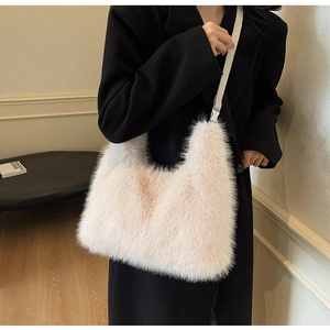 Hobo plush shoulder bag in creamy white fur styled with a black coat for women