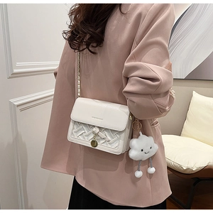 Detail of white woven leather crossbody bag with gold chain and cute plush cloud charm