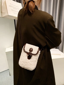 Fleece crossbody bag with faux leather trim and toggle closure shown on a model
