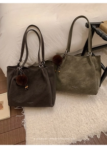 Detailed view of large capacity tote bags in dark brown and olive green with fur ball charms