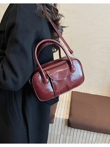 Side view of wine red oil wax leather bowling bag showing polished finish and strap