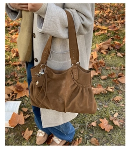 Detail of dark brown faux suede tote bag featuring metallic rivets and star charms