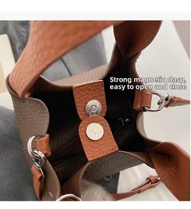 Detail of caramel leather bucket bag featuring strong magnetic buckle and inner zip pocket