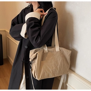Khaki large canvas tote bag with adjustable strap shown on model in home setting