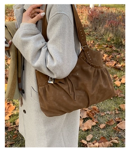 Detail of silver studs and pleated texture on large brown suede tote bag