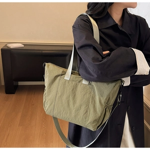 Detail of army green large capacity tote bag with elastic side pockets and wide strap