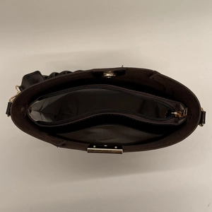 Interior view of black tote bag showing central zipper pocket and magnetic buckle