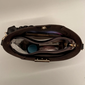 Internal view of the retro bucket bag showing textured lining and zipper compartments