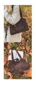 Close-up of retro dark brown suede tote with silver rivets and star pendant detail