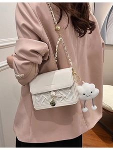 Chic white crossbody bag with woven texture, gold bead chain, and plush cloud charm