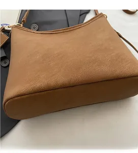 Close-up of brown matte faux leather bag with gold MIKAXIQI logo and fine stitching