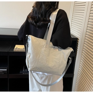 Detail view of large canvas tote bag with adjustable shoulder strap and drawstring side pocket