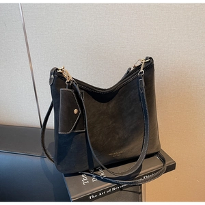 Detail of black suede Hobo bag with white contrast stitching and gold logo branding