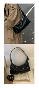 Detail view of black studded hobo bag on model and white sofa display