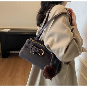 Detail of vintage brown suede shoulder bag with leather strap and decorative golden buckle