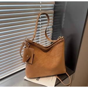 Detail of a vintage brown leather tote bag featuring a detachable mini pouch and gold logo