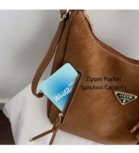 Detail view of brown lychee grain leather shoulder bag with side zipper and metal logo