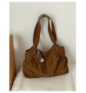 Detail of vintage brown suede tote with pleats and silver star pendant charms