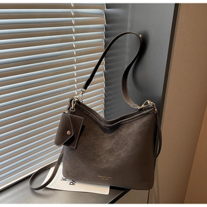 Detail of grey suede hobo bag with adjustable strap and small decorative pouch