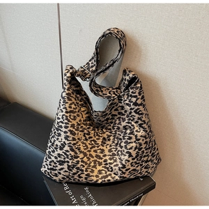 Detail view of large leopard print tote bag featuring a wide adjustable strap and front pocket