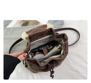 Detail showing interior space of brown suede drawstring backpack with soft fleece lining