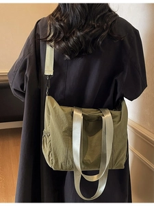 Olive green large capacity canvas tote bag with adjustable strap worn by model