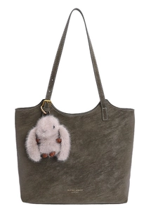 Olive green tote bag with luxury texture and cute rabbit charm in a front view