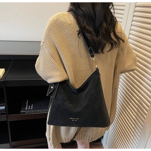 Detail of black Hobo shoulder bag with white contrast stitching and printed logo