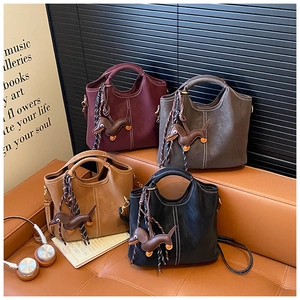 Minimalist bucket bags in four colors with contrast stitching and dachshund charms