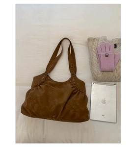 Flat lay of large brown suede tote bag with silver studs and daily winter accessories