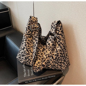 Detail of leopard print tote bag with adjustable shoulder strap and silver hardware buckle
