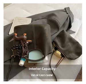 Detail showing internal capacity of brown matte bucket bag with a small inner pouch