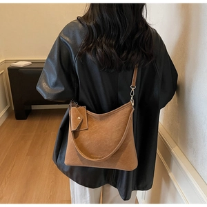 Detail view of large brown Hobo crossbody bag with matching envelope pouch on handle